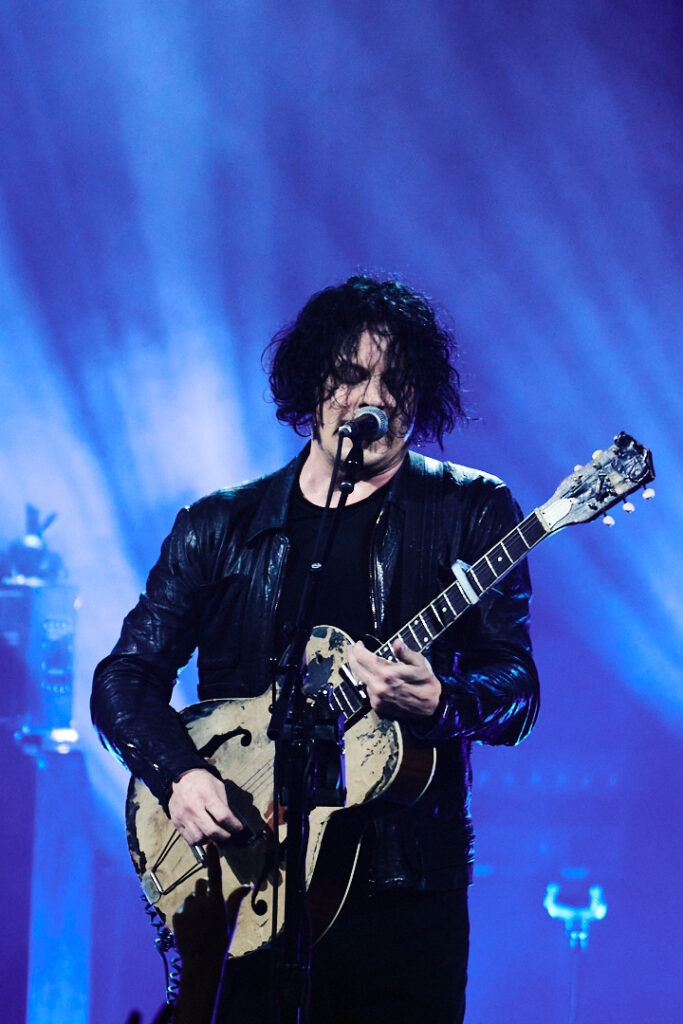 Jack White chante sur scène avec sa guitare